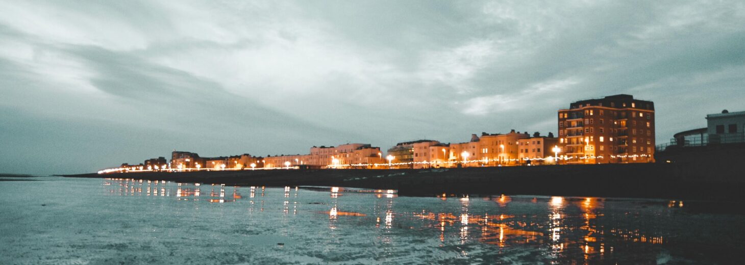 This picture shows a nighttime view of Worthing from the beach looking up to at the houses and hotesls.